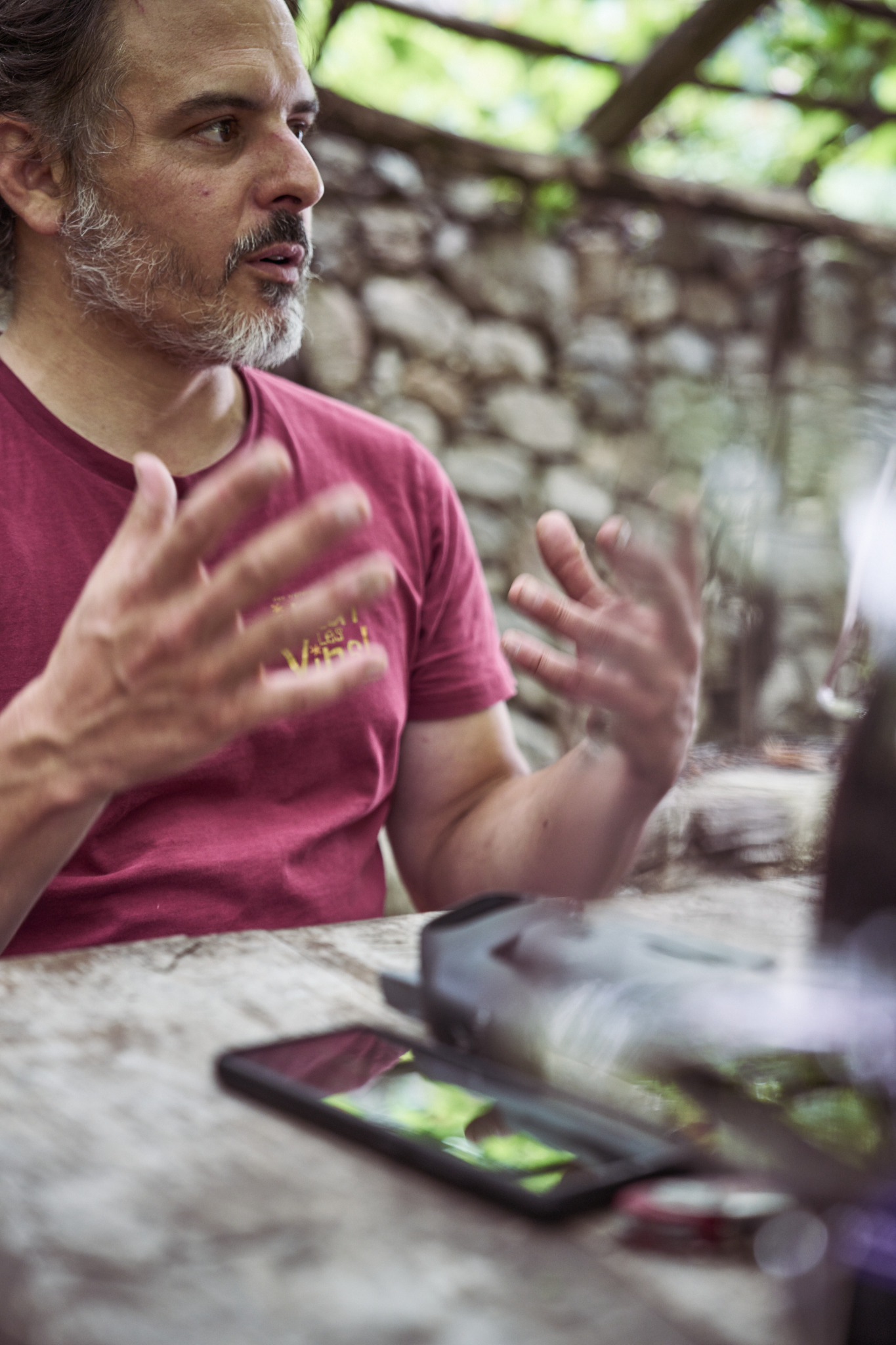 Dominic Würth im Gespräch an einem Tisch unter einer Pergola
